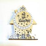  Házikó alakú adventi naptár fenyőkkel, szarvassal, HDF. Mérete: 16, 5x21, 5