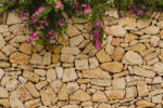 Dimex Vlies Fotótapéta - Stone wall with blooms - 375x250 cm (MS-5-2382)